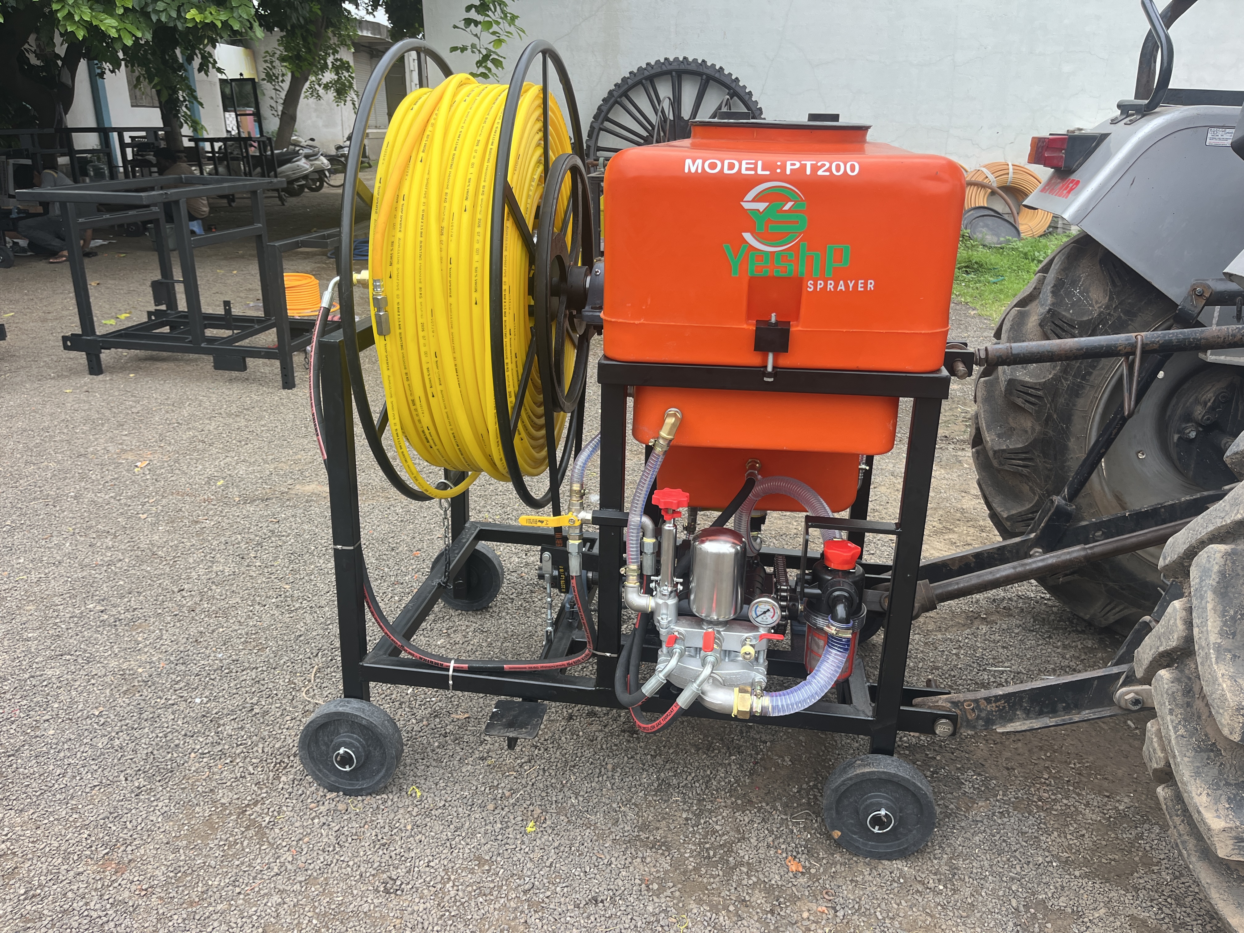 YeshP Sprayer PT200 with yellow hose reel beside a tractor